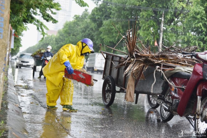 Công nhân môi trường TP. Vinh dầm mưa quét dọn rác, khơi thông cống